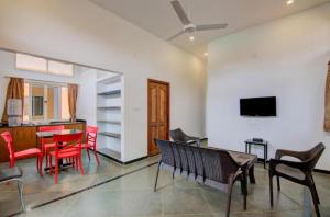 a living room with red chairs and a table at Auro Wellness Castle in Puducherry