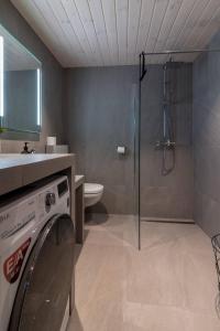 a bathroom with a washing machine and a shower at Leilighet med fantastisk utsikt in Henningsvær