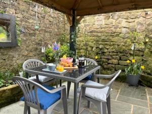 - une table et des chaises sur une terrasse avec de la nourriture dans l'établissement Beautiful 2-Bed Cottage in Heysham Village, à Heysham