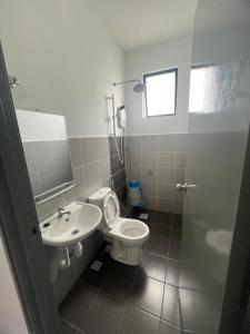 a bathroom with a toilet and a sink at 75 Suite (Tower B) in Papar