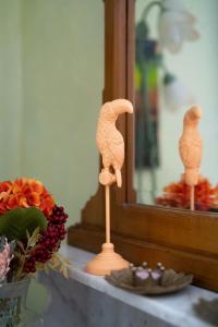 una statuina di uccello di legno su un tavolo accanto a uno specchio di CASA BELGERI a Dongio
