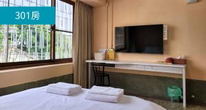 a hotel room with a bed with a tv on the wall at Romance Guest House in Dalin