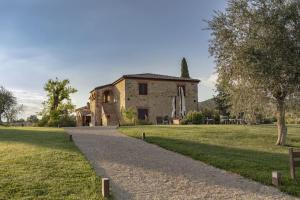 ein altes Steingebäude mit einem Weg davor in der Unterkunft Wine Resort Campacci in San Gusmè + 26 Fotos