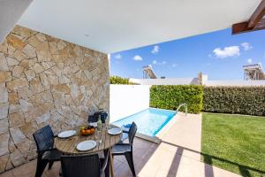 un patio avec une table et des chaises et une piscine dans l'établissement Villa Back Loop, à Sagres