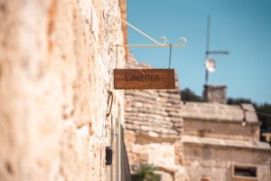 a wooden sign on the side of a building at Trulli Beauty Romantic ALCOVA con piscina in Locorotondo