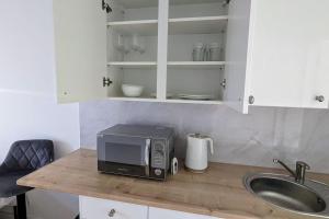 a microwave sitting on a counter next to a sink at Southend Airport Ground Floor Studio, with parking in Southend-on-Sea