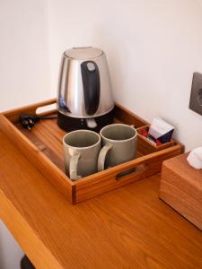a coffee maker and two cups on a wooden shelf at Catu Glamping Bedugul in Tabanan