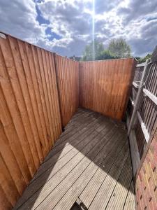 a wooden fence next to a wooden deck at Southend Airport Ground Floor Studio, with parking in Southend-on-Sea