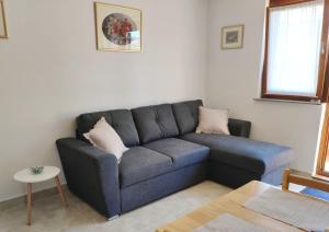 a living room with a blue couch and a table at Apartment Jelena in Fažana
