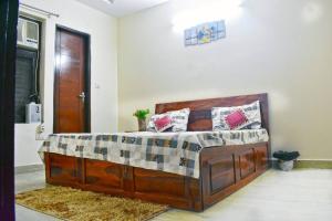 a bedroom with a large wooden bed in a room at Budget Friendly 3 BHK + Prime Location in Faridabad