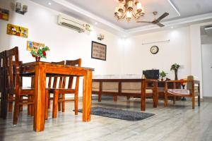 a dining room and living room with a table and chairs at Budget Friendly 3 BHK + Prime Location in Faridabad