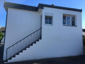 a white building with a staircase and a window at Studio - Le Pouliguen in Le Pouliguen