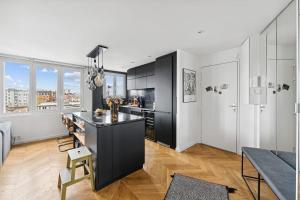 a kitchen with black and white cabinets and a table at Le Michelet - Appartement lumineux in Saint-Ouen