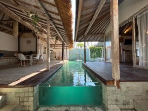 an indoor swimming pool in a house with at Camilla Resort in Gili Air