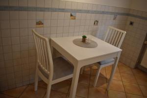 une table blanche avec deux chaises et une plante sur elle dans l'établissement Ferienwohnung Rhönmarkt, à Ostheim