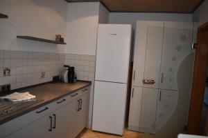 La cuisine est équipée d'un réfrigérateur blanc. dans l'établissement Ferienwohnung Rhönmarkt, à Ostheim