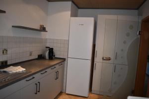 a kitchen with a white refrigerator in a kitchen at Ferienwohnung Rhönmarkt in Ostheim