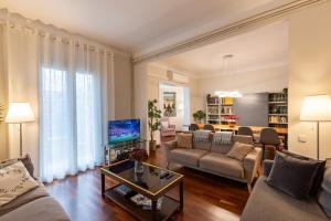 uma sala de estar com um sofá e uma televisão em Large & beautiful apartment 4min from Passeig de Gràcia em Barcelona