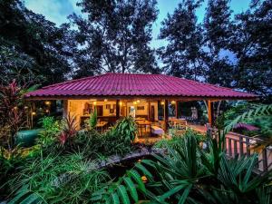 a small house with a purple roof in a garden at Mayura Hill Resort in Sen Monorom