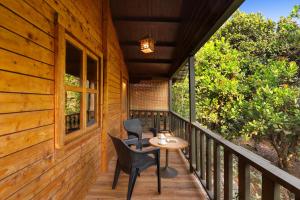 a porch of a cabin with chairs and a table at Keys Lite by Lemon Tree Hotels Sylvan, Dapoli in Dapoli