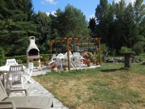 un jardín con sillas blancas y una hoguera en La Madriguera Accommodation, en Gardes-le-Pontaroux