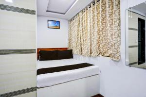 Habitación pequeña con cama y ventana en Hotel Metro House en Bombay