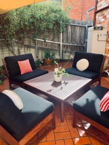 a patio with a wooden table and two chairs at La Rouge Cottage in Bendigo