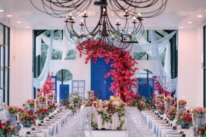 a wedding aisle with white tables and flowers at The Arjana Resort in Masjid Tanah