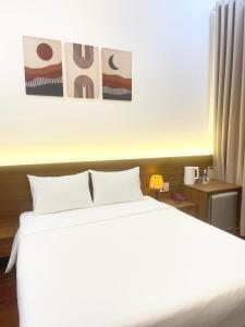 een slaapkamer met een groot wit bed en een nachtkastje bij Ngọc Toàn Hotel in Dong Hoi
