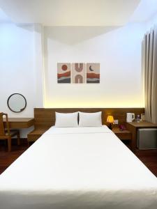 een slaapkamer met een groot wit bed en een raam bij Ngọc Toàn Hotel in Dong Hoi