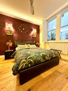 een slaapkamer met een bed met een kleurrijke sprei bij 2 Bedroom Apartment in Central London South Kensington in Londen