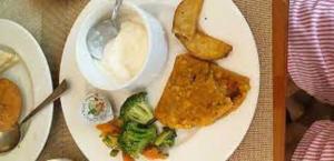 a plate of food with broccoli and a bowl of sauce at Hotel Airport Sinon by Dream Laxmi New Delhi At IGI Airport in New Delhi