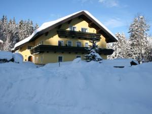 a house with a pile of snow in front of it at Scenic Apartment in Krispl Salzburg with Swimming Pool in Krispl