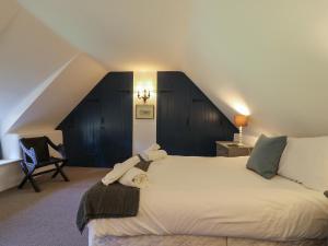 una camera da letto con un letto con un animale di peluche sopra di Lychgate Cottage a Osmington