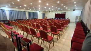 una habitación llena de sillas rojas y un podio en Hotel Chautari pvt ltd, en Nagarkot