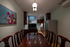 a dining room with a table and chairs and a refrigerator at Bare Hyphen - Bare Boutique Stays in Ho Chi Minh City