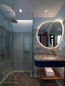 a bathroom with a sink and a mirror at Bare Hyphen - Bare Boutique Stays in Ho Chi Minh City +18 photos
