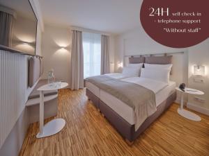 um quarto com uma cama grande e duas mesas em Classik Hotel Hackescher Markt - Self Check In em Berlim