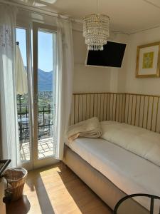 a bedroom with a bed and a large window at Pensione Olanda in Locarno