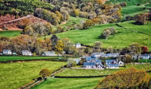 una vista aérea de un pueblo en las colinas en Bwthyn Heddwch - Peace Cottage, en Machynlleth