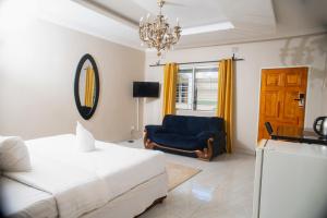 una camera con letto, sedia e lampadario a braccio di Fatmols City Hotel a Ndola