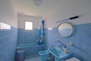ペネスタンにあるLes Tamaris - A moins d'un km de la plageの青いバスルーム(シンク、鏡付)