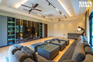 sala de estar con sofá grande y TV en StayVista's Hampton Acres - Outdoor Pool, Vast Lawn & Terrace, en Dhauj