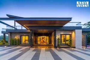 una representación de una casa por la noche con luces en StayVista's Hampton Acres - Outdoor Pool, Vast Lawn & Terrace, en Dhauj