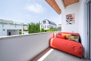 un sofá rojo en un balcón con vistas en Stylish 4BR Villa - Herzliya Pituah en Herzelia 