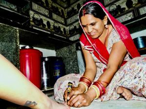 una mujer sentada en un estante sosteniendo una mano de persona en Pukhraj Garh- A Heritage Homestay, en Jodhpur