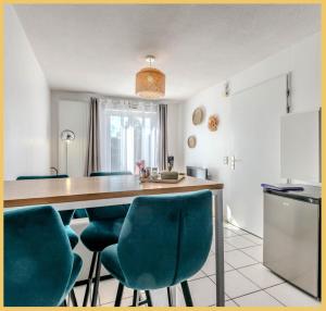 een keuken met een houten tafel en blauwe stoelen bij Appartement Le Blansin in Saint Pierre en Faucigny
