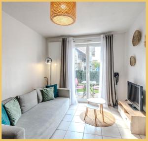 a living room with a couch and a tv at Appartement Le Blansin in Saint Pierre en Faucigny