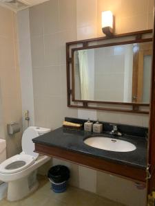 y baño con lavabo, aseo y espejo. en Khách Sạn Bông Sen, en Dong Quan