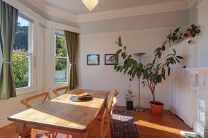 Villa Cambria في نيلسون: غرفة طعام مع طاولة وكراسي خشبية